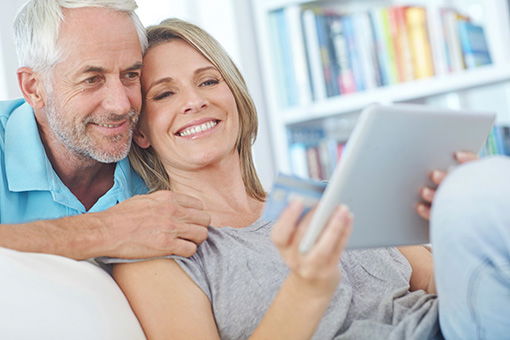 Man and Woman using online banking with a tablet and debit card